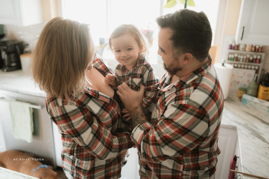 Family snuggling in matching PJs as an example of what to wear for family photos at home 