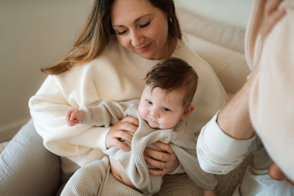 Mom and baby snuggle on the bed as an example of winter family photo outfits