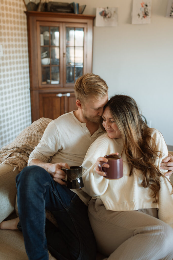 Mom and dad snuggle on the couch as an example of winter family photo outfits