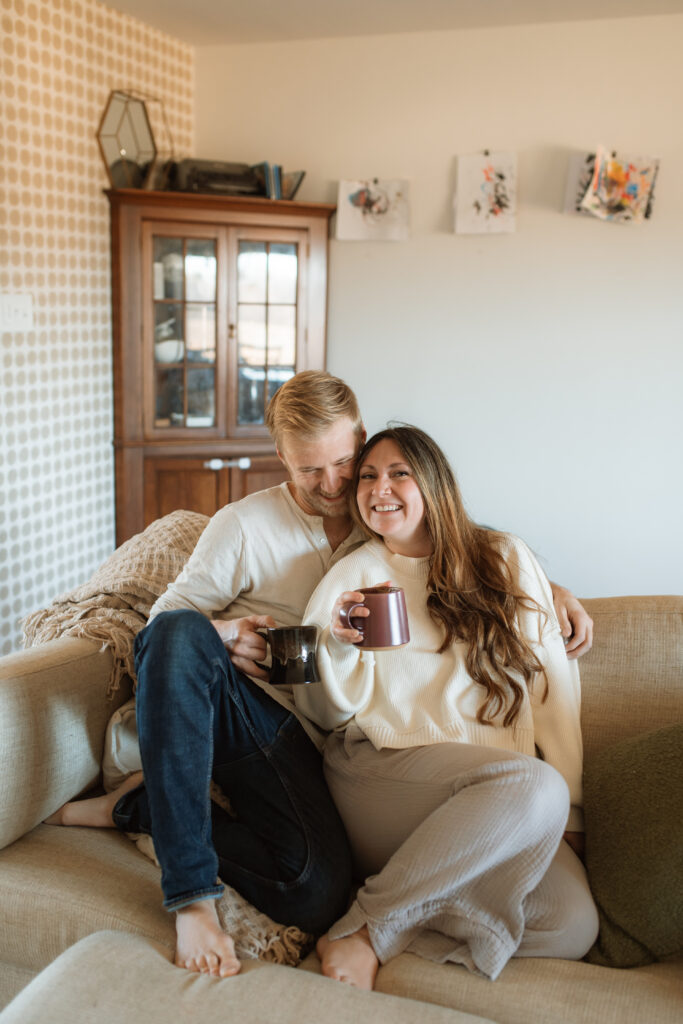 Mom and dad snuggle on the couch as an example of winter family photo outfits