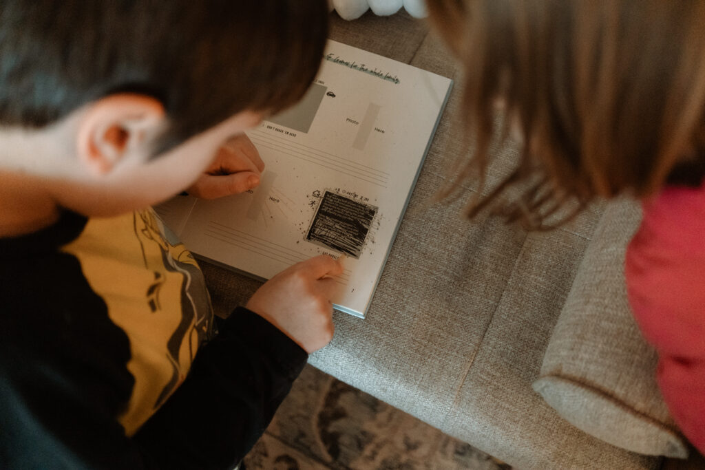 Kids scratch off activity in The Adventure Challenge Family Edition to find a family activity to do at home. 