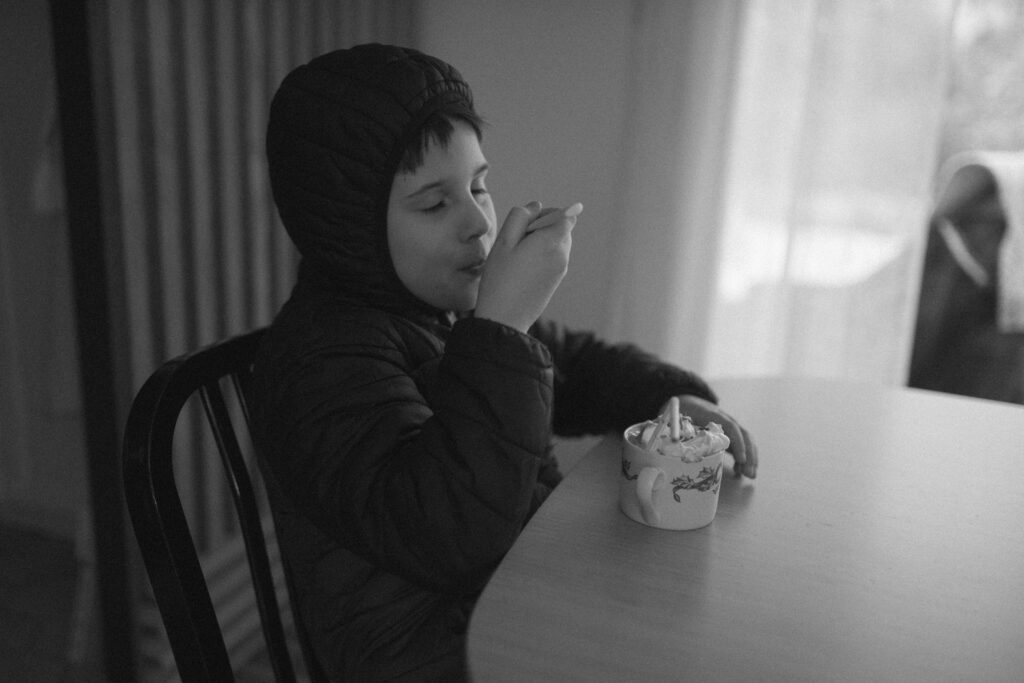 Boy drinking hot chocolate as an example of snow photo ideas 