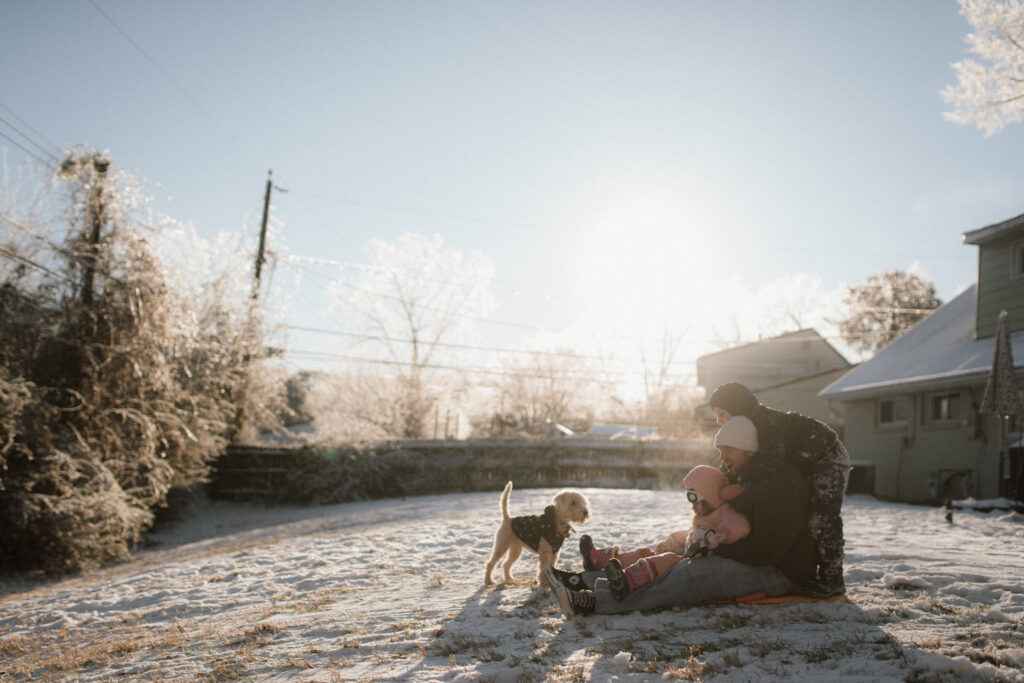 Dad sledding with kids and dog as an example of snow photo ideas