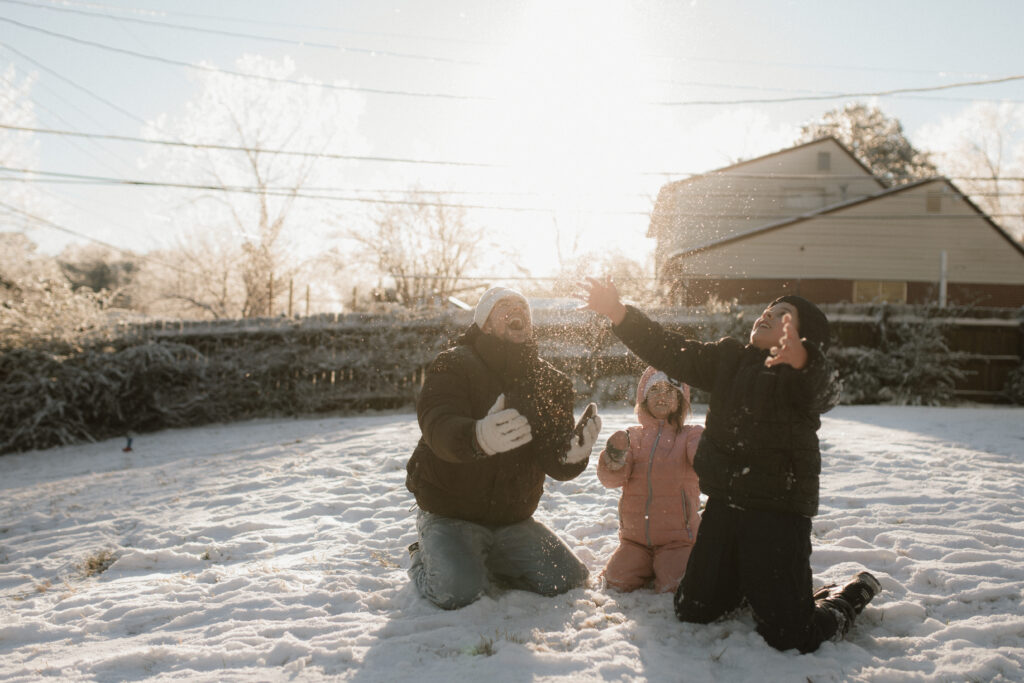 Father and kids throwing snow as an example of snow photo ideas