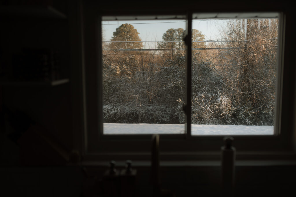 Snowy landscape outside of a window as an example of snow photo ideas 