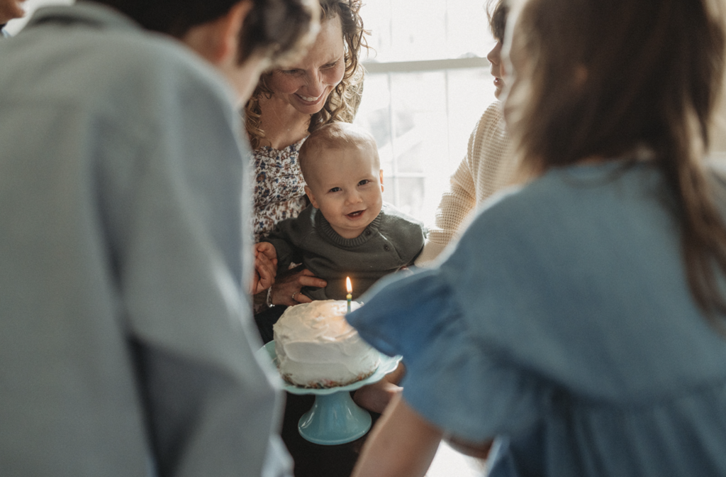 Mom in floral dress holds baby as an example of what to wear for family photos at home