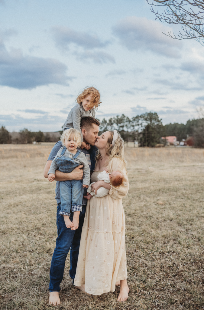 Family snuggles in a field for spring family photo session in Richmond, VA 