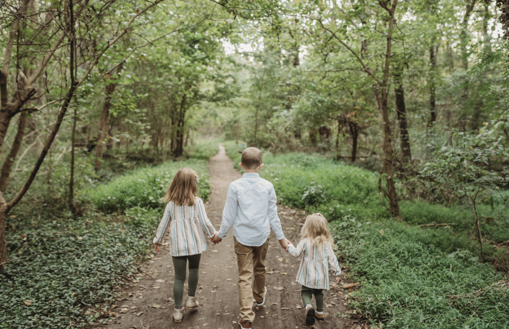 Three siblings walk through a park for spring family photos in Richmond, VA 