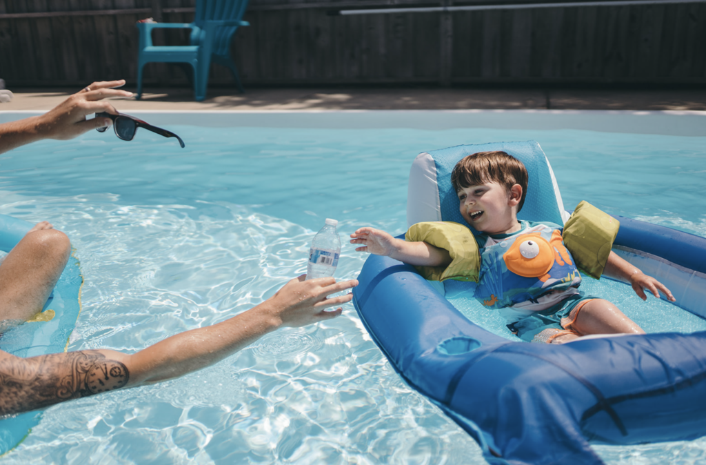 Dad and son play in the pool as an example of family photo location ideas. 