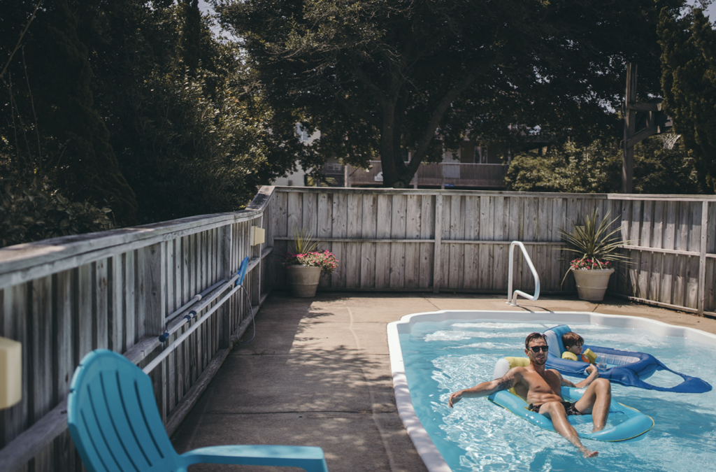 Dad and son float in the pool as an example of family photo location ideas. 